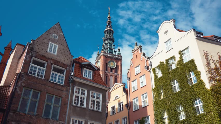 Low angle shot of town Hall and St. Mary's Basilica behind polish architecture houses in Gdansk, Poland.