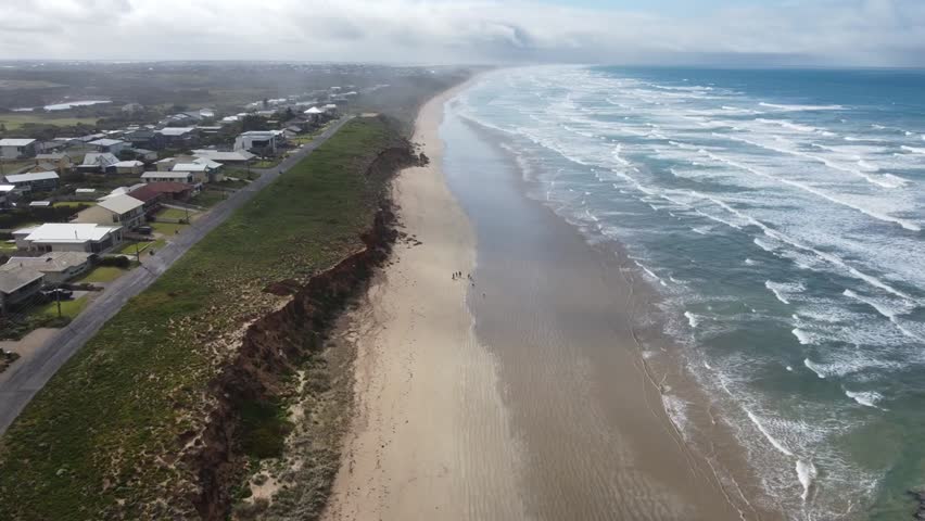 A great view of Middleton Beach on the Fleurieu Peninsula in South Australia Split with Beachfront Housing on one side and the beach on the other and great clouds and mist in the distance