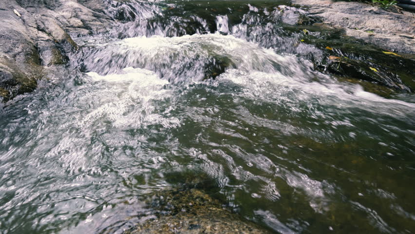 A stormy stream flows over the stepped stones, forking