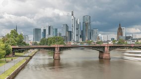 Aerial hyperlapse of Frankfurt skyline with Main River and Ignatz Bubis Bridge. Skyscrapers and church spires reflected in the water beneath dramatic clouds timelapse. Frankfurt, Germany - Powered by Shutterstock - Get 15% off with code: PIKWIZARD15