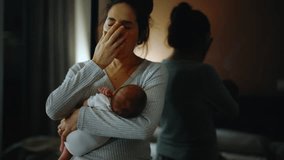 Authentic footage of a mother in pajamas at night trying to put her newborn baby to sleep in her arms. The mother is very tired and yawns and cuddles her baby in the bedroom - Powered by Shutterstock - Get 15% off with code: PIKWIZARD15