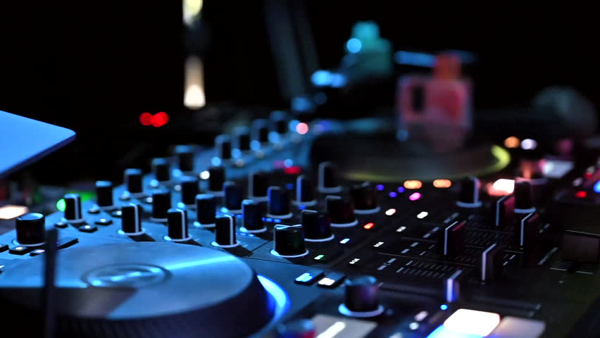 Close-up of the hands of a DJ working in a nightclub at the console.