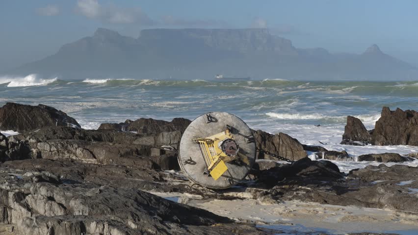 drifting weather buoy washed up on shore after a storm at Blouberg Beach with Table Mountain seen in background