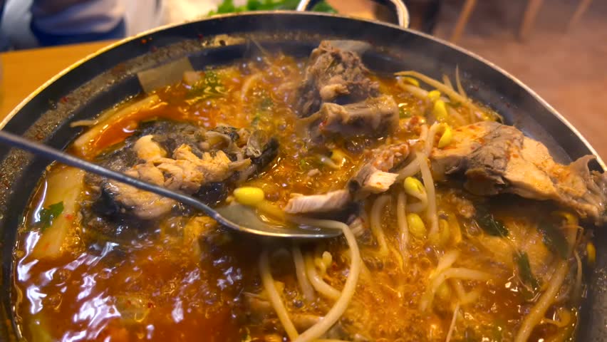 Spicy fish soup simmers in hot pot, rich broth simmers with fresh fish, bean sprouts and aromatic spices. Traditional Asian fish dish for those who like spicy food. Fish is healthiest product