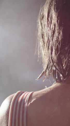 Steam rise from woman stepping out of hot sauna into brisk winter air, vertical