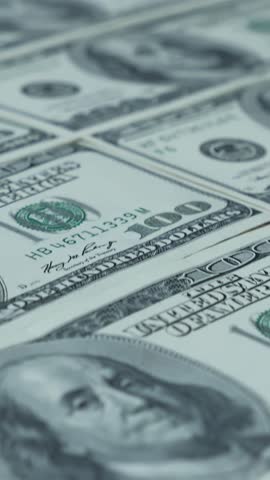 Sheet of US one hundred dollar banknotes. Printing of dollar cash money. Finance and economy concept. Dollars background. Conveyor of money. Vertical video
