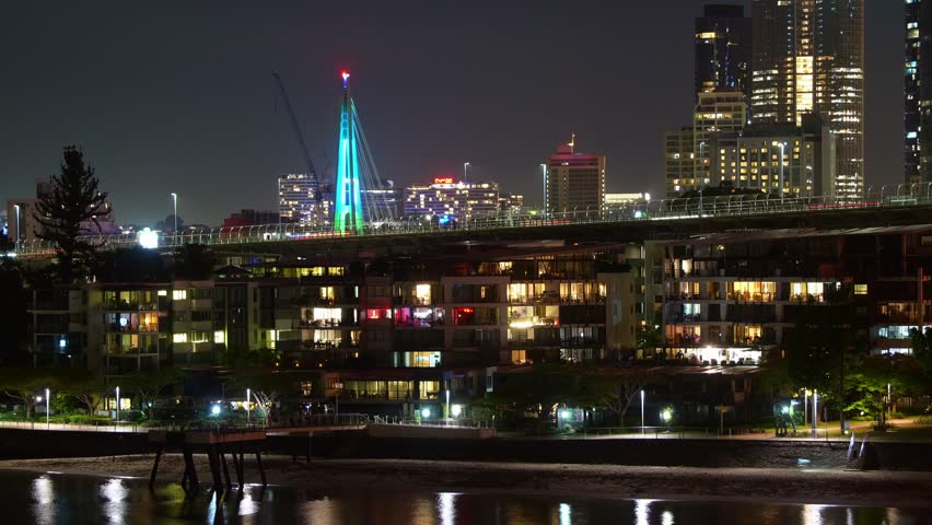 Time-lapse shot capturing illuminated riverside apartments in Kangaroo Point and traffics on Story bridge at night, Brisbane city, Queensland.