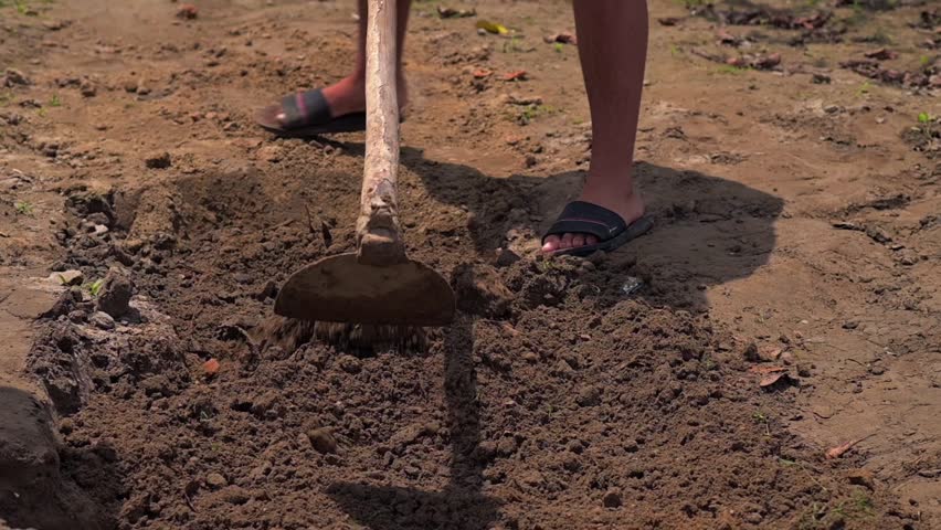 Man working with a shovel in soil, preparing land in a rural Amazonian village
