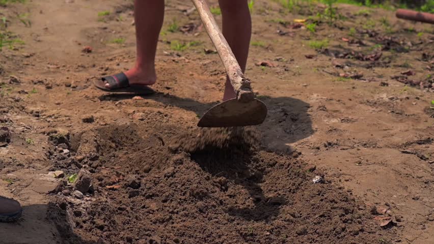 Man working with a shovel in soil, preparing land in a rural Amazonian village