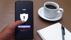 Hand holding smartphone with login screen display. On the brown table there. - Powered by Shutterstock - Get 15% off with code: PIKWIZARD15