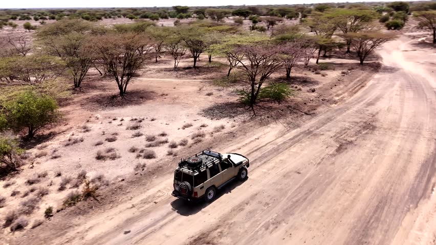 Drone following Land Rover type of vehicle in the African Savannah