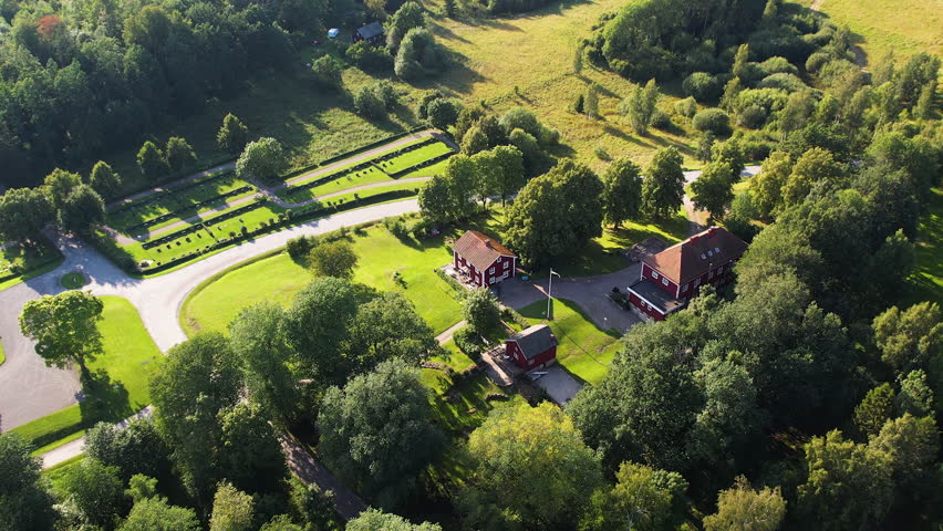 Push in drone shot of Skalleruds Gard scenic accommodation next to Lake Naren in the day in West Sweden