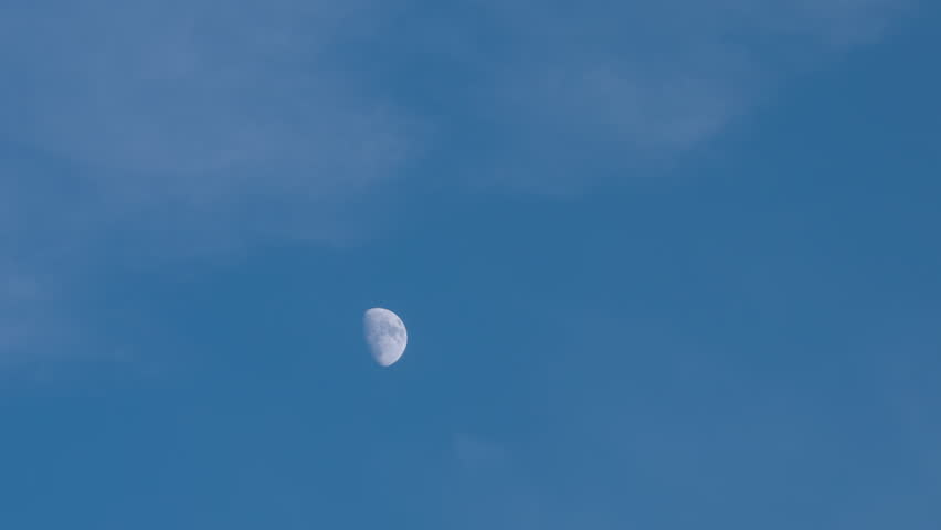 Time lapse of moon and scattered clouds durings sunset