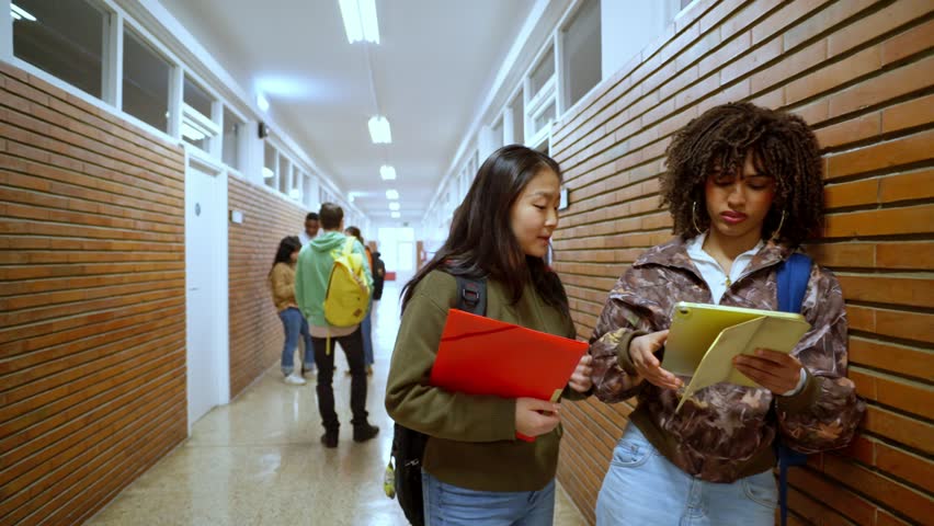 Students discussing notes in university hallway