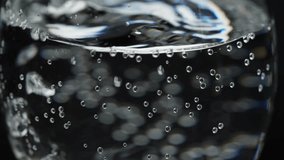 Close up of effervescent bubbles in sparkling water rising dynamically in a clear glass, slow motion - Powered by Shutterstock - Get 15% off with code: PIKWIZARD15