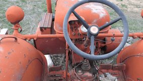 A look at the steering wheel of an old tractor that has stood the test of time. With its worn orange body and rusty details, it bears the traces of agriculture and labor. - Powered by Shutterstock - Get 15% off with code: PIKWIZARD15