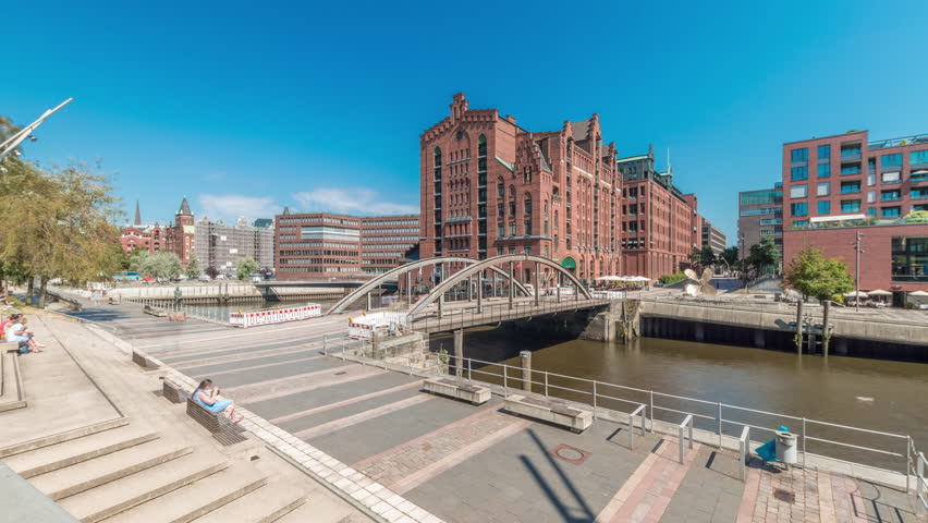Panorama showing famous old Speicherstadt in Hamburg timelapse featuring the International Maritime Museum, iconic brick buildings, arch bridges, canals and waterfront. A historic landmark in Germany