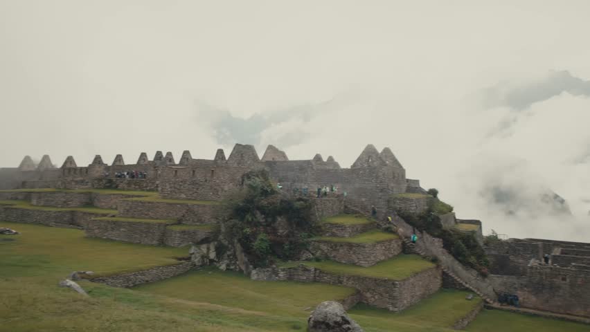 Tourists Visit The Historic Machu Picchu Sanctuary In The Andes Mountains In Peru. Aerial Panning Shot