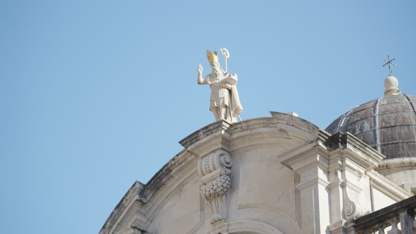 Clos up of the statue of St. Blasius holidng a rod on top of his Church with the same name in Old Town Dubrovnik Croatia with a clear blue sky in the summer