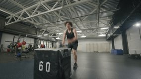 Muscular man in sportswear performing powerful box jumps in spacious gym during functional training session with padded plyometric box - Powered by Shutterstock - Get 15% off with code: PIKWIZARD15