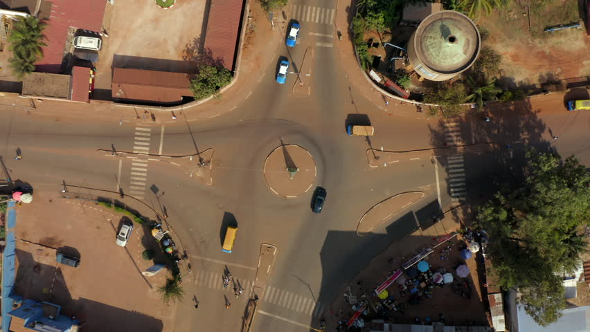 Land Transport And Pedestrian At Roundabout In City Of Bissau, Guinea-Bissau. aerial topdown shot