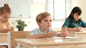 Caucasian boy raising hand for asking and answering teacher surrounded by diverse children studying at classroom. Happy student working together, voting, volunteering, calling instructor. Pedagogy. - Powered by Shutterstock - Get 15% off with code: PIKWIZARD15