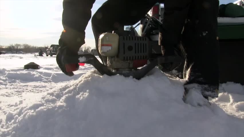A Man is Employing an Ice Auger for Ice Angling - Close Up