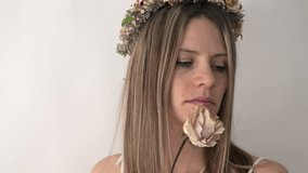 The camera captures a close-up of the bride’s face. She holds a vibrant rose, and a delicate floral crown adorns her head. Her green eyes gaze directly into the lens, exuding a sense of serene beauty. - Powered by Shutterstock - Get 15% off with code: PIKWIZARD15