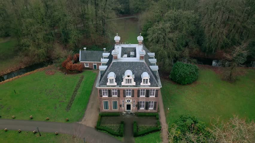 Drone view of Doornburgh estate in Maarssen, Netherlands, showcasing its symmetrical architecture, manicured gardens, and surrounding wooded area. A well-preserved example of Dutch cultural heritage.