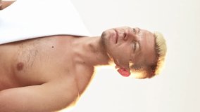 Vertical video. Man freshness. Morning routine. Confident shirtless blond guy with athletic body towel on bare shoulder touching short hair after shower isolated on white. - Powered by Shutterstock - Get 15% off with code: PIKWIZARD15