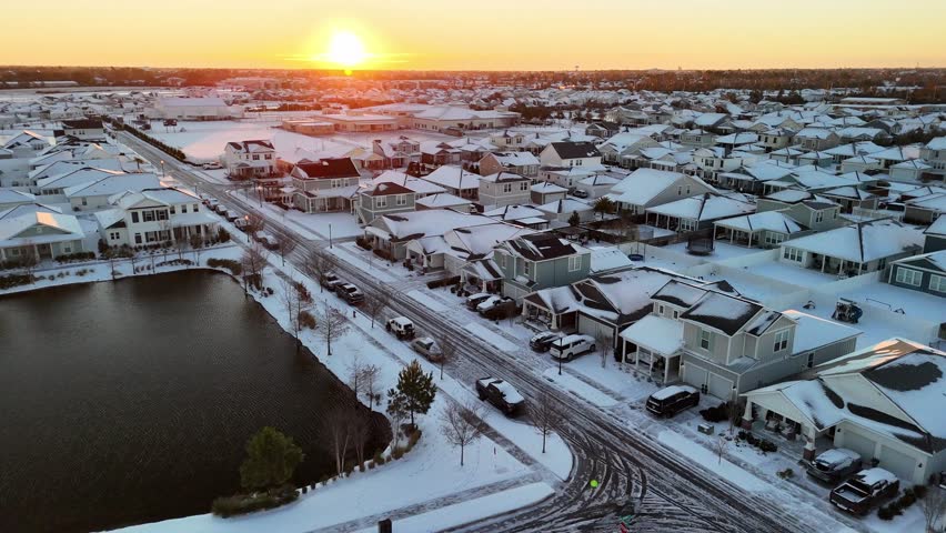 Aerial view over icy streets in middle of homes, unique snowy evening in Florida