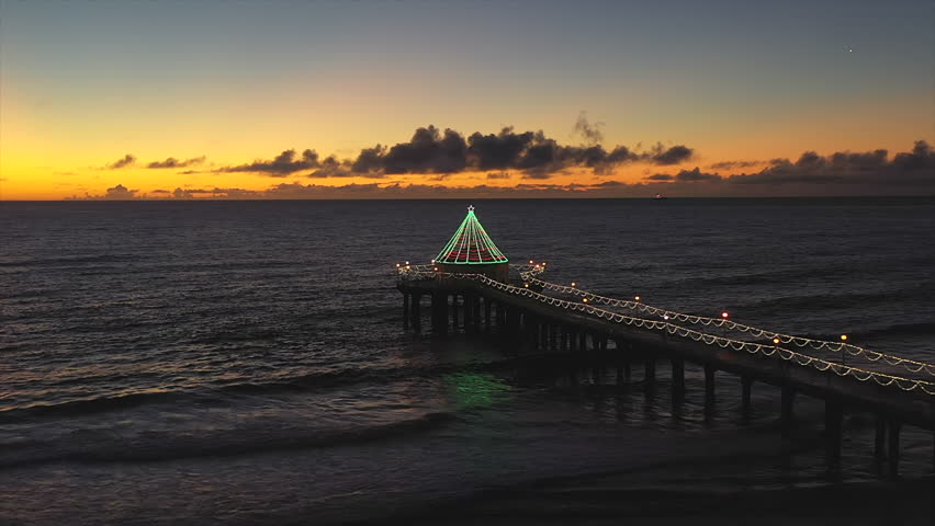 Manhattan Beach Pier And Roundhouse Aquarium Decorated With Christmas Lights At Night. - aerial shot