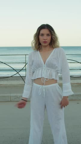 Girl Dances In White Clothes Outside On The Street Near The Ocean