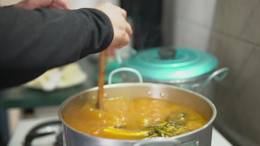 Grandmother teaching granddaughter to cook traditional latin soup
