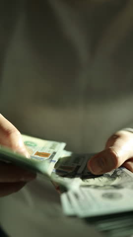 Person counts dollar banknotes in hands. Man counting American money by his hands, closeup. the concept of investment, money exchange, economy and finance. A man counting dollar money in his hand