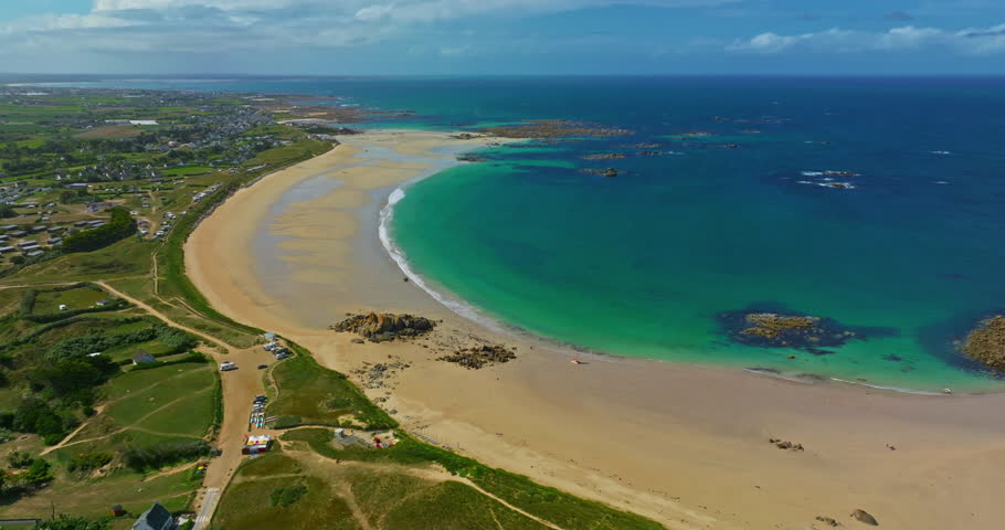 Aerial view of the tranquil beach at Plage des Amiets with clear turquoise water and waves