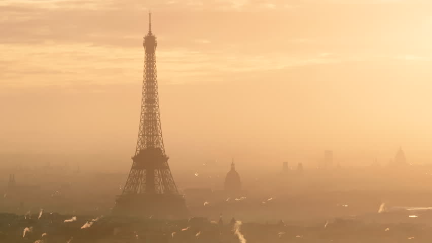 Tight circling shot of the Eiffel tower and Hôtel des Invalides at sunrise