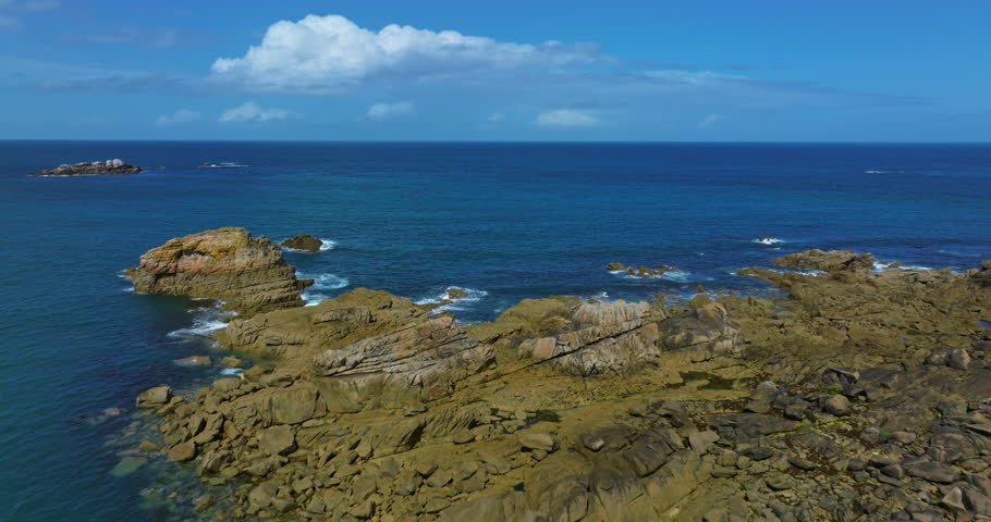 Aerial view of the tranquil beach at Plage des Amiets with clear turquoise water and waves