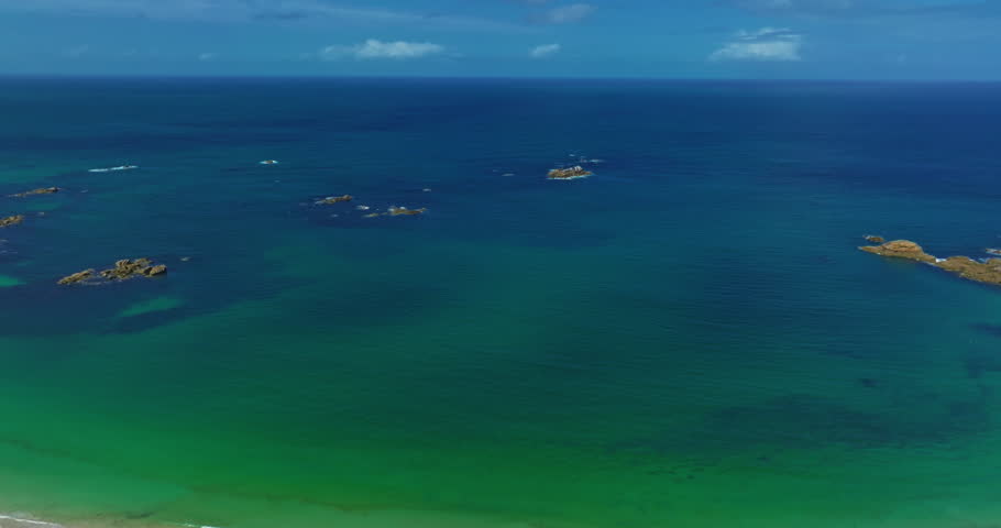 Aerial view of the tranquil beach at Plage des Amiets with clear turquoise water and waves