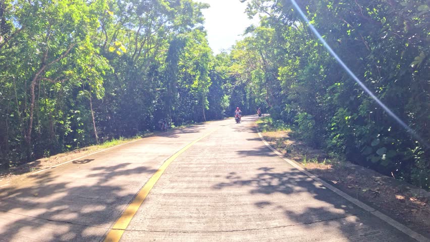 Point of view driving scooter motorbike along Asian roads surrounded by lush tropical rainforests and small towns Philippines Thailand  travelling adventure lifestyle 

