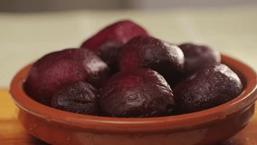Raw peeled vegetable beet in plate on wooden table close-up. Preparing raw vagetables food for cooking. Cooking traditional Russian Borsch.  - Powered by Shutterstock - Get 15% off with code: PIKWIZARD15