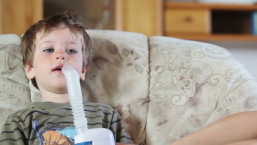 Mother and little boy using nebulizer to inhale medicine, front view panning