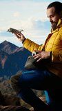 Vertical Video Trekking enthusiast captures his activity on video using a drone footage, documenting the scenic mountain range valley. Filming beautiful aerial view vlog with remote control device - Powered by Shutterstock - Get 15% off with code: PIKWIZARD15