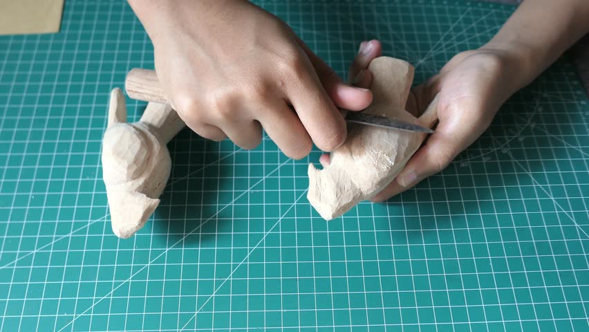 a hand is doing bird wood carving footage video