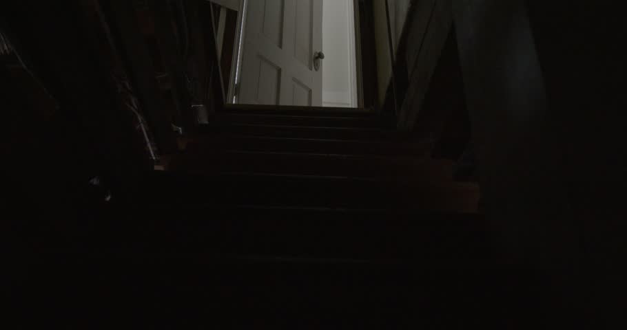 Wide Tilt Up Shot of a Dark and Creepy Basement Staircase