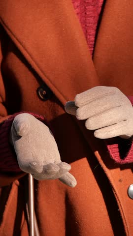 Sophisticated Winter Ensemble Featuring Warm Gloves and a Vibrant Orange Coat