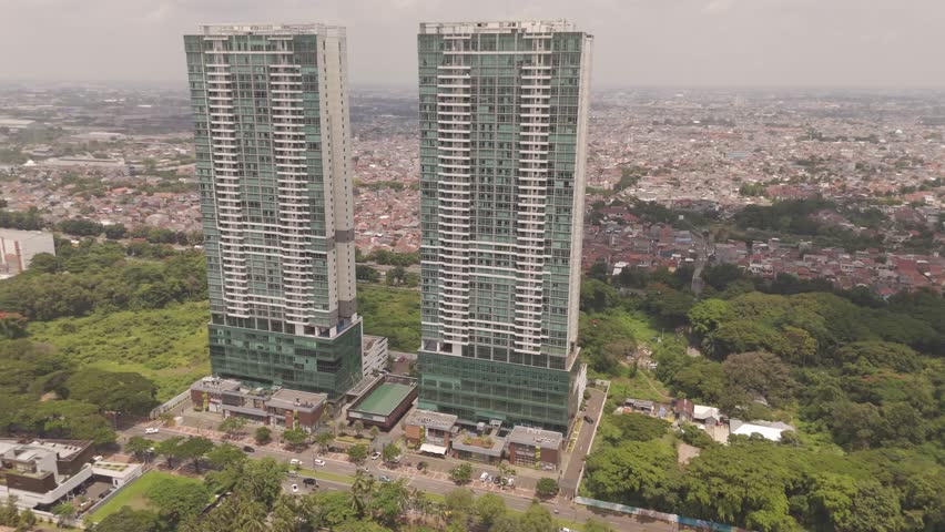 Stunning aerial footage of twin residential apartment towers in Tangerang, Jakarta, Indonesia, showcasing real estate, urban development, and modern cityscape architecture projects.