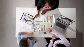 Real Estate Consultant Showing Apartment Blueprint To Couple Client - Powered by Shutterstock - Get 15% off with code: PIKWIZARD15