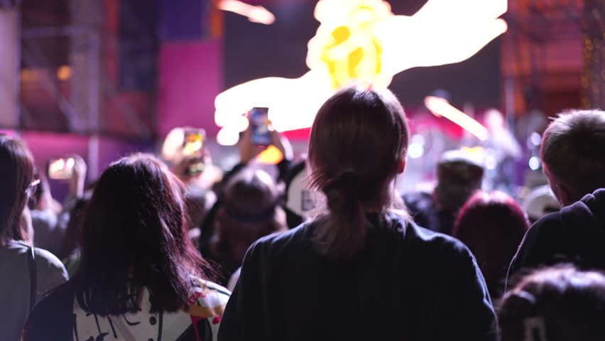 Lot teens dance kpop music concert. Many young men fans cheering fun party. Joy crowd teenagers hang out cool night life fest, k pop chill. Epic live arena. Neon disco light. People enjoy band song.