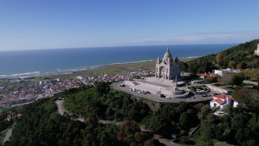 Aerial drone footage revealing the Basilica of Santa Luzia, the coastal town of Viana do Castelo, and the Atlantic Ocean. A breathtaking view of Portugal’s scenic landscape and historic architecture